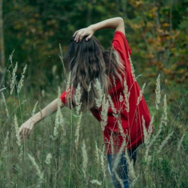 a woman standing in a field of tall grass