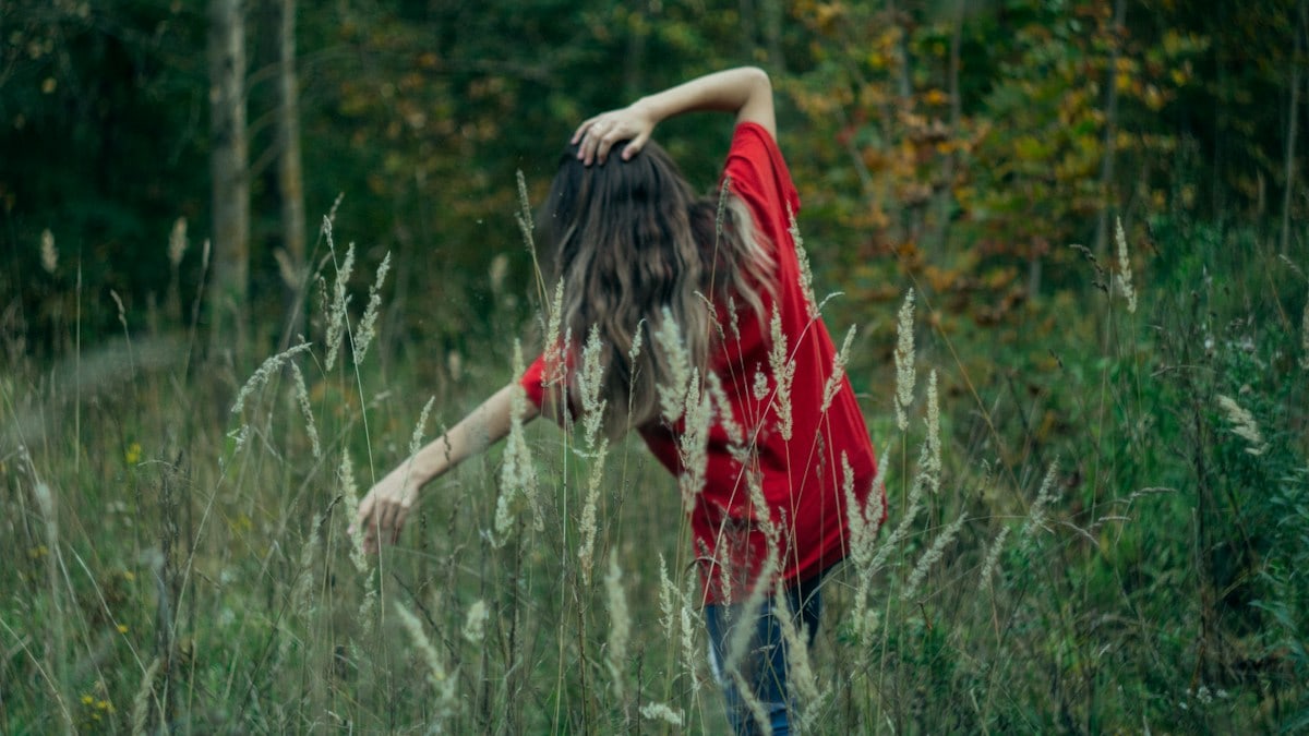 a woman standing in a field of tall grass